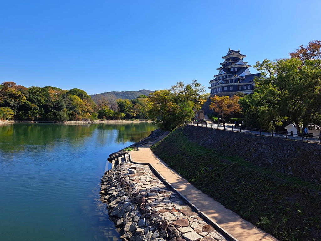 【岡山】岡山城半日遊-坐鎮於高地上的「烏城」黑武士 - 第6張圖 橋上的岡山城與旭川景色